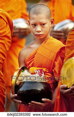 "Monks walking in the street in the early morning tradition of gathering alms in Chiang Mai, Thailand, Asia" View Large Photo Image Stock Image - "Monks walking in the street in the early morning tradition of gathering alms in Chiang Mai, Thailand, Asia". Fotosearch