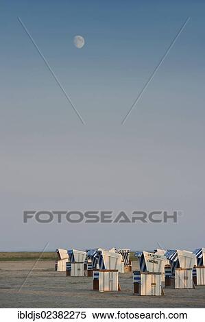 Stock Photography - "Moon above the beach of St. Peter-Ording with roofed wicker beach chairs, North Frisia, Schleswig-Holstein, Germany, Europe". Fotosearch