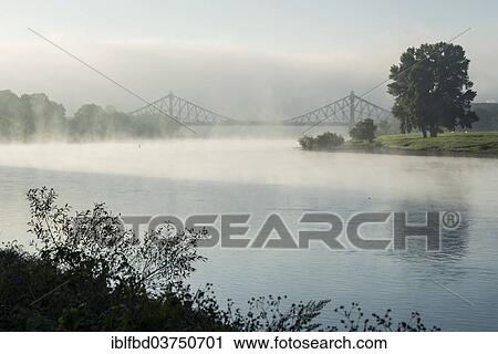 "Morning fog on the Elbe river, Loschwitz Bridge or Blue Wonder bridge at the back, Dresden, Saxony, Germany, Europe" View Large Photo Image Stock Image - "Morning fog on the Elbe river, Loschwitz Bridge or Blue Wonder bridge at the back, Dresden, Saxony, Germany, Europe". Fotosearch