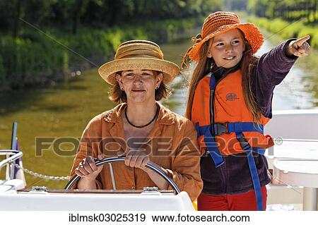 "Mother and daughter at the wheel of a Penichette, houseboat on the Canal de Pont-de-Vaux, Pont-de-Vaux, Pont-de-Vaux, Region Rhone-Alpes, Dep. Ain, France, Europe" View Large Photo Image Stock Photo - "Mother and daughter at the wheel of a Penichette, houseboat on the Canal de Pont-de-Vaux, Pont-de-Vaux, Pont-de-Vaux, Region Rhone-Alpes, Dep. Ain, France, Europe". Fotosearch