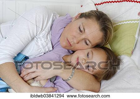 "Mother and daughter cuddling in bed, hugging" View Large Photo Image Picture - "Mother and daughter cuddling in bed, hugging". Fotosearch