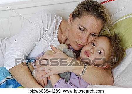 "Mother and daughter cuddling in bed, hugging" View Large Photo Image Stock Photo - "Mother and daughter cuddling in bed, hugging". Fotosearch