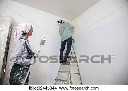 "Mother and daughter renovating a room, painting the walls with paint rollers" View Large Photo Image Picture - "Mother and daughter renovating a room, painting the walls with paint rollers". Fotosearch