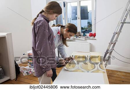 "Mother and daughter renovating a room, preparing wallpaper for wallpapering the walls" View Large Photo Image Stock Photograph - "Mother and daughter renovating a room, preparing wallpaper for wallpapering the walls". Fotosearch