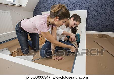 "Mother and daughter working together to assemble a bed in the daughter's room, bed assembly set, Germany, Europe" View Large Photo Image Stock Photo - "Mother and daughter working together to assemble a bed in the daughter's room, bed assembly set, Germany, Europe". Fotosearch