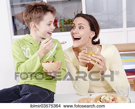 "Mother and son eating fresh fruit and granola, Germany, Europe" View Large Photo Image Picture - "Mother and son eating fresh fruit and granola, Germany, Europe". Fotosearch