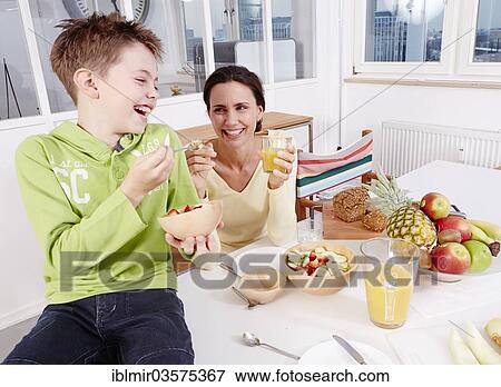 Stock Photo - "Mother and son eating fresh fruit and granola, Germany, Europe". Fotosearch