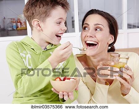 Stock Photograph - "Mother and son eating fresh fruit and granola, Germany, Europe". Fotosearch