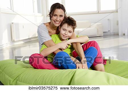 "Mother and son in casual clothes sitting on a beanbag in a loft, Germany, Europe" View Large Photo Image Stock Photography - "Mother and son in casual clothes sitting on a beanbag in a loft, Germany, Europe". Fotosearch