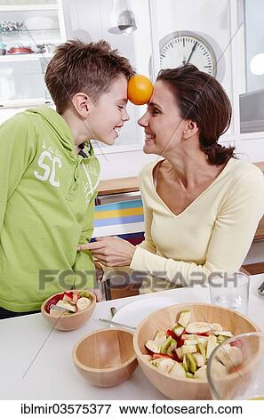 Mother and son playing at home with an orange View Large Photo Image Stock Photo - Mother and son playing at home with an orange. Fotosearch
