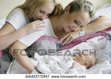 Mother in the hospital with her older daughter and a newborn baby View Large Photo Image Stock Photo - Mother in the hospital with her older daughter and a newborn baby. Fotosearch