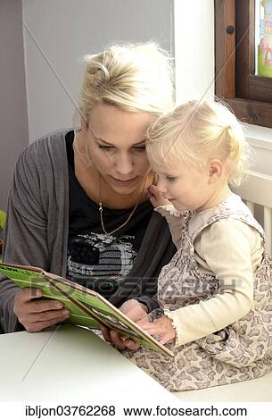 Stock Photo - "Mother reading a book with her little daughter, Sweden, Europe". Fotosearch