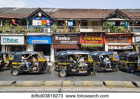 Stock Image - "Motor rikshaws parked in front of a row of old houses, Bandra, Mumbai, Maharashtra, India, Asia". Fotosearch