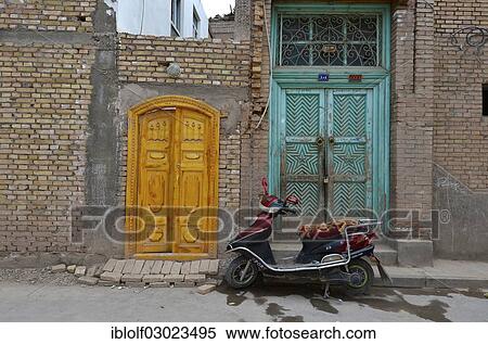 "Motor scooter in front of old Uighur Muslim doorframes in new homes, Kashgar, Seidenstrasse, Xinjiang, China, People's Republic of China, Asia" View Large Photo Image Stock Photography - "Motor scooter in front of old Uighur Muslim doorframes in new homes, Kashgar, Seidenstrasse, Xinjiang, China, People's Republic of China, Asia". Fotosearch