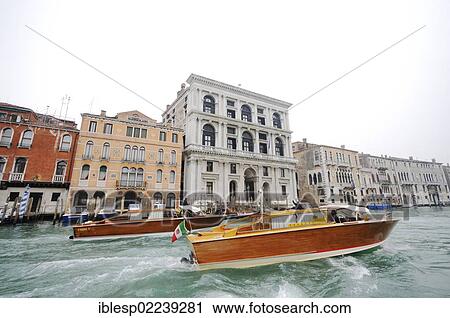 Stock Image - "Motorboat on the Grand Canal, Canal Grande, with the Palazzo Grimani di San Luca and the Palazzo Corner Contarini dei Cavalli, San Marco quarter, Venice, Venezia, Veneto, Italy, Europe". Fotosearch