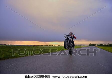"Motorcyclist in front of a dramatic cloudy sky, Mindelheim, Unterallgau District, Bavaria, Germany, Europe" View Large Photo Image Stock Photo - "Motorcyclist in front of a dramatic cloudy sky, Mindelheim, Unterallgau District, Bavaria, Germany, Europe". Fotosearch