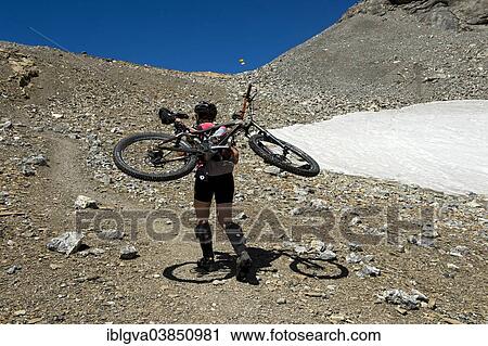 "Mountain biker carrying his bike on a steep single trail in the mountains, Bernese Alps, Switzerland, Europe" View Large Photo Image Stock Image - "Mountain biker carrying his bike on a steep single trail in the mountains, Bernese Alps, Switzerland, Europe". Fotosearch