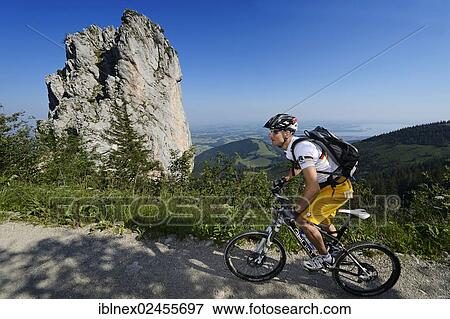 "Mountain biker cycling in front of Staffelstein rock at Mt Kampenwand, Kampen, Chiemgau, Upper Bavaria, Bavaria, Germany, Europe" View Large Photo Image Stock Photo - "Mountain biker cycling in front of Staffelstein rock at Mt Kampenwand, Kampen, Chiemgau, Upper Bavaria, Bavaria, Germany, Europe". Fotosearch
