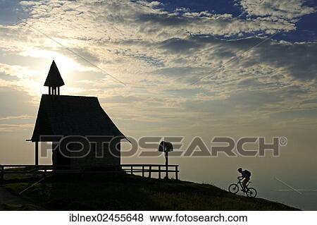 "Mountain bikers at the Chapel of Steinling Alm, silhouette against the light, Kampenwand Mountain, Chiemgau, Upper Bavaria, Bavaria, Germany, Europe" View Large Photo Image Stock Photo - "Mountain bikers at the Chapel of Steinling Alm, silhouette against the light, Kampenwand Mountain, Chiemgau, Upper Bavaria, Bavaria, Germany, Europe". Fotosearch