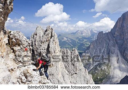 Picture - "Mountain climber ascending Plattkofel Mountain along the Oskar-Schuster Stieg climbing route, Via Ferrata, in front of the Odle Mountains, Val Gardena, Dolomites, Alto Adige, Italy, Europe". Fotosearch