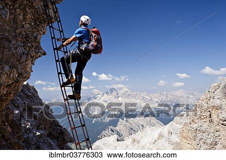 "Mountain climber ascending the Via Ferrata Marino Bianchi climbing route on Cristallo di Mezzo Mountain, overlooking the Tofane Mountains, Dolomites, Belluno, Italy, Europe" View Large Photo Image Stock Image - "Mountain climber ascending the Via Ferrata Marino Bianchi climbing route on Cristallo di Mezzo Mountain, overlooking the Tofane Mountains, Dolomites, Belluno, Italy, Europe". Fotosearch