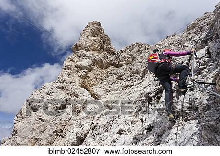 Stock Photo - "Mountain climber during the ascent of Kesselkogel Mountain in the Rosengarten Group, Trentino, Italy, Europe". Fotosearch