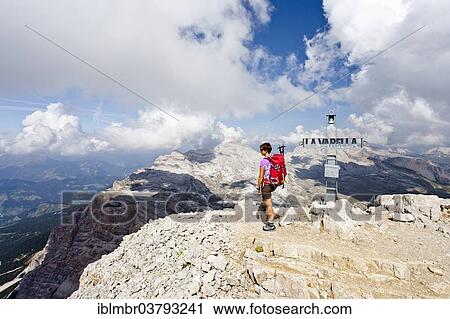 Stock Image - "Mountain climber on the summit of Lavarela Massif, overlooking the mountains of Heiligkreuzkofel, Zehner and Neuner, Fanes-Sennes-Prags Nature Park, Val Badia, Dolomites, Alto Adige, Italy, Europe". Fotosearch