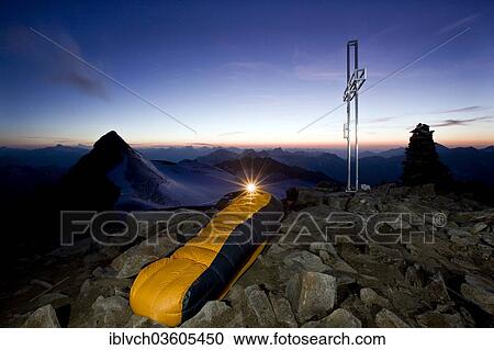Stock Image - "Mountain climber sleeping on the summit of Wilder Pfaff Mountain, bivouac at the summit cross, Stubai Valley, Stubai Alps, Tyrol, Austria, Europe". Fotosearch
