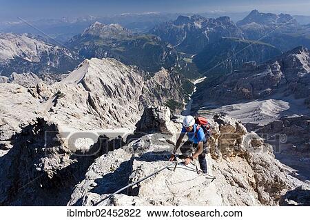"Mountain climbers decending along the Via Ferrata Marino Bianchi climbing route on Mount Cristallo, Belluno, Dolomites, Italy, Europe" View Large Photo Image Stock Image - "Mountain climbers decending along the Via Ferrata Marino Bianchi climbing route on Mount Cristallo, Belluno, Dolomites, Italy, Europe". Fotosearch