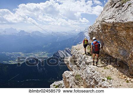 "Mountain climbers descending down the Via Ferrata Ivano Dibona climbing route on the summit of Cristallino on Monte Cristallo, view towards the village of Cortina, Marmolada Mountain at the rear, Belluno, Dolomites, Italy, Europe" View Large Photo Image Stock Photo - "Mountain climbers descending down the Via Ferrata Ivano Dibona climbing route on the summit of Cristallino on Monte Cristallo, view towards the village of Cortina, Marmolada Mountain at the rear, Belluno, Dolomites, Italy, Europe". Fotosearch