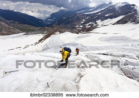 "Mountain climbers setting a safety peg while walking on the flank of Zufallferner Glacier in the Martell Valley above Marteller Huette hut, Alto Adige, Italy, Europe" View Large Photo Image Stock Photography - "Mountain climbers setting a safety peg while walking on the flank of Zufallferner Glacier in the Martell Valley above Marteller Huette hut, Alto Adige, Italy, Europe". Fotosearch
