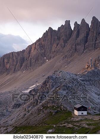 Stock Image - "Mountain hut with view of Mt Paternkofel at dawn, Tre Cime di Lavaredo, Dolomiti di Sesto National Park, Sexten Dolomites, Hochpustertal, High Puster Valley, South Tyrol, Italy, Europe". Fotosearch