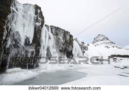 "Mountain Kirkjufell behind frozen waterfall Kirkjufellsfoss in the snow, Snaefellsnes Peninsula, Iceland, Europe" View Large Photo Image Stock Photo - "Mountain Kirkjufell behind frozen waterfall Kirkjufellsfoss in the snow, Snaefellsnes Peninsula, Iceland, Europe". Fotosearch
