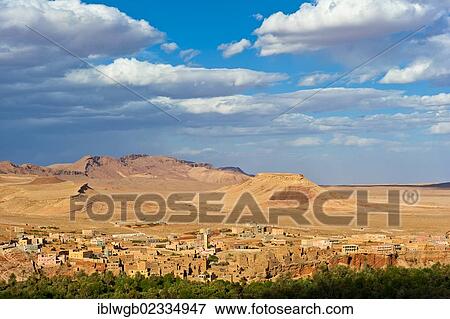 Stock Photo - "Mountain landscape and mud brick village of the Berber people with mosque and newly built homes, Tinerhir, southern Morocco, Morocco, Africa". Fotosearch