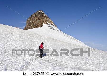 Stock Image - "Mountaineer on Mt Pfaffensattel, peak of Mt Zuckerhutl at back, North Tyrol, Austria, Europe". Fotosearch