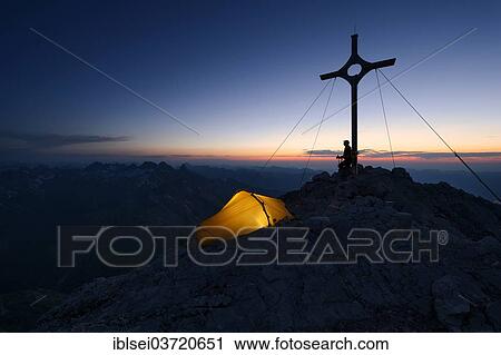 "Mountaineer with a tent at the summit cross on Grosser Krottenkopf Mountain at dusk, Allgauer Alpen, Tyrol, Austria, Europe" View Large Photo Image Stock Image - "Mountaineer with a tent at the summit cross on Grosser Krottenkopf Mountain at dusk, Allgauer Alpen, Tyrol, Austria, Europe". Fotosearch