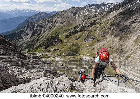 "Mountaineers at the Imst via ferrata during the ascent of Mt Maldenkopf in the Lechtal Alps, at the back Mt Vorderes Alpjoch, Hoch-Imst, Imst, Tyrol, Austria, Europe" View Large Photo Image Stock Image - "Mountaineers at the Imst via ferrata during the ascent of Mt Maldenkopf in the Lechtal Alps, at the back Mt Vorderes Alpjoch, Hoch-Imst, Imst, Tyrol, Austria, Europe". Fotosearch