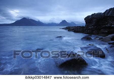 "Mountains shrouded with clouds, blue hour on a rocky seashore, Elgol, Isle of Skye, Scotland, United Kingdom, Europe" View Large Photo Image Stock Photo - "Mountains shrouded with clouds, blue hour on a rocky seashore, Elgol, Isle of Skye, Scotland, United Kingdom, Europe". Fotosearch