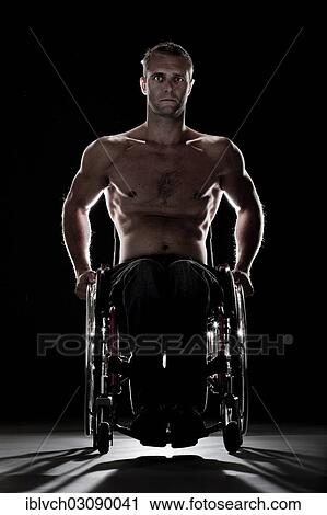 Stock Image - "Muscular wheelchair user with a bare chest, feeling uneasy, Innsbruck, Tyrol, Austria, Europe". Fotosearch