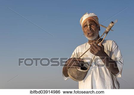 Stock Photograph - "Musician playing an Ektara, a traditional one-string instrument, Vrindavan, Uttar Pradesh, India, Asia". Fotosearch