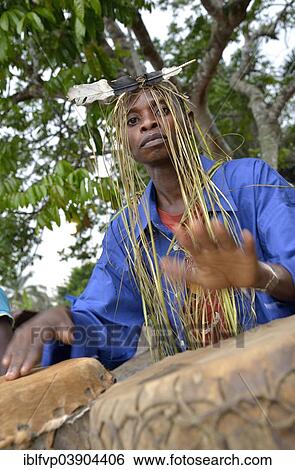 "Musician with a headdress made of bast and a feather, playing drums, Nkala, Bandundu Province, Democratic Republic of the Congo" View Large Photo Image Stock Photograph - "Musician with a headdress made of bast and a feather, playing drums, Nkala, Bandundu Province, Democratic Republic of the Congo". Fotosearch