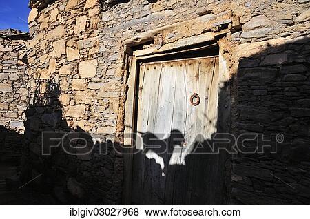 Stock Photo - "Natural stone walls, old house with a wooden door, shadow of a dog on the door, Tizourgane, Souss-Massa-Draa, Antiatlas, Morocco, Africa". Fotosearch