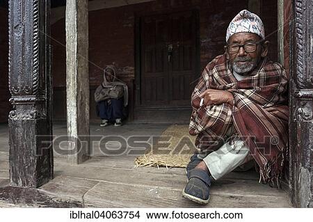 Picture - "Nepalese man wrapped in a blanket sitting at an entrance, Bhaktapur, Nepal, Asia". Fotosearch