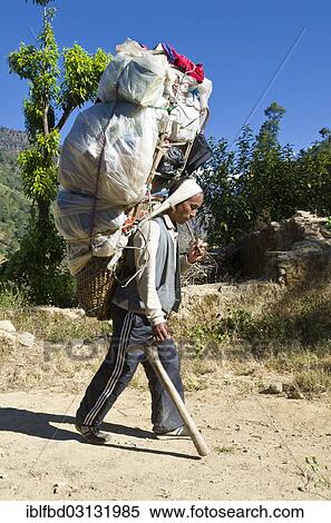 "Nepali Porter carrying a big load from Kinja up to Lamjura La (3530m), near Khincha, Solukhumbu District, Sagarmatha Zone, Nepal, Asia" View Large Photo Image Stock Photography - "Nepali Porter carrying a big load from Kinja up to Lamjura La (3530m), near Khincha, Solukhumbu District, Sagarmatha Zone, Nepal, Asia". Fotosearch