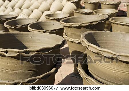 Stock Photo - "Newly made pottery is drying in the sun before getting burned, Kathmandu Valley, Thimi, Kathmandu District, Bagmati Zone, Nepal, Asia". Fotosearch