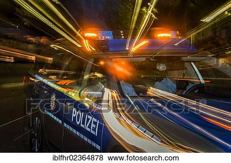 Stock Photo - "Night shot of a moving police car, Duesseldorf, North Rhine-Westphalia, Germany, Europe". Fotosearch