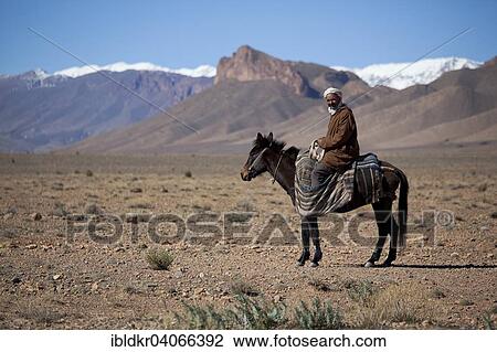 Stock Image - "Nomad Berber riding a horse, Atlas Mountains, Morocco, Africa". Fotosearch