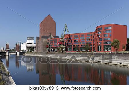 "NRW State Archives, archive tower of the former RWSG warehouse, with newly constructed buildings with a curved facade, Innenhafen, Duisburg, Ruhr district, North Rhine-Westphalia, Germany, Europe" View Large Photo Image Stock Image - "NRW State Archives, archive tower of the former RWSG warehouse, with newly constructed buildings with a curved facade, Innenhafen, Duisburg, Ruhr district, North Rhine-Westphalia, Germany, Europe". Fotosearch