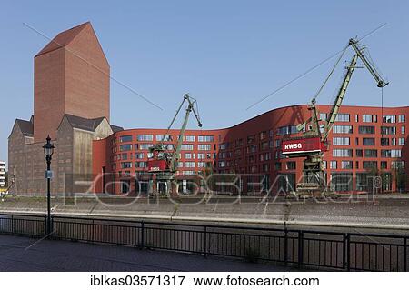 "NRW State Archives, archive tower of the former RWSG warehouse, with newly constructed buildings with a curved facade, Innenhafen, Duisburg, Ruhr district, North Rhine-Westphalia, Germany, Europe" View Large Photo Image Stock Photo - "NRW State Archives, archive tower of the former RWSG warehouse, with newly constructed buildings with a curved facade, Innenhafen, Duisburg, Ruhr district, North Rhine-Westphalia, Germany, Europe". Fotosearch