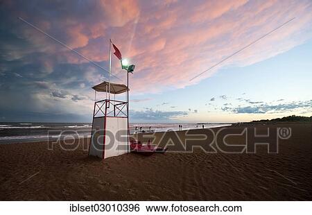 Stock Photograph - "Observation tower on the sea with moody clouds and the afterglow of sunset, Cavallino, Jesolo, Venedig, Italy, Europe". Fotosearch